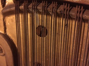 Heavily rusted strings on an old upright