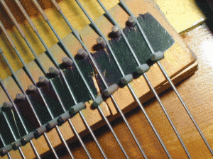 This bridge is severely cracked and will make these notes buzz. The bridge is at the opposite end of the string as the keys.